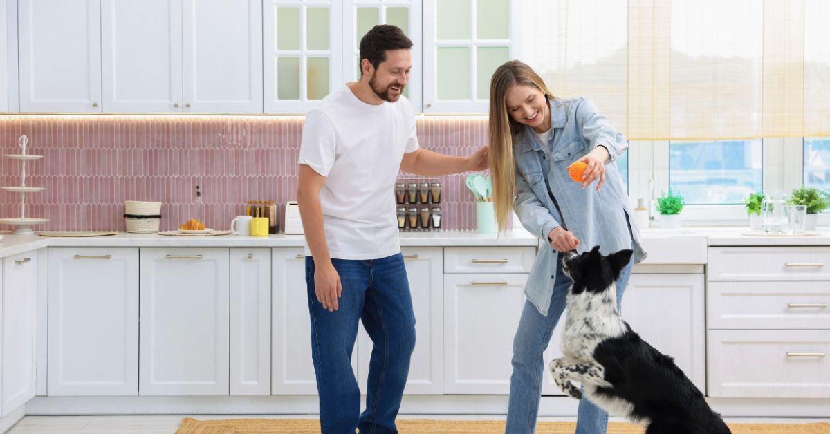 happy couple playing with their dog in their new kitchen thinking of what to expect from their local HVAC Company
